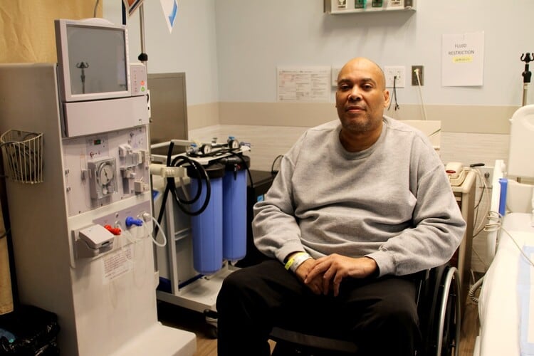 man sitting in wheelchair by equipment